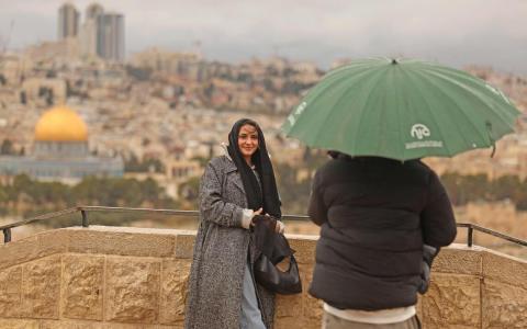 目前，以色列境内约有4万多名游客，图为去年12月，游客在耶路撒冷橄榄山拍照留念。（法新社）