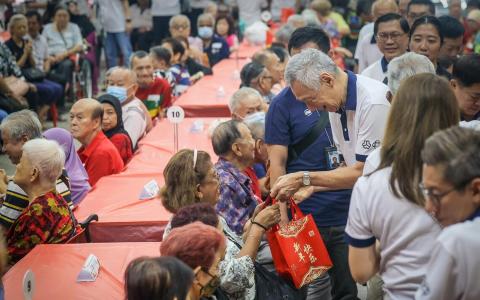 国务资政李显龙星期天（2月1日）在德义民众俱乐部举办的农历新年庆祝会上，分发度岁金给400多名年长居民。（张俊杰摄）