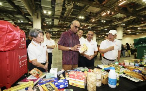 尚达曼总统（左二）在国家福利理事会会长范秀平（左一）、外交部兼社会及家庭发展部政务部长周凯年（右二），以及福袋活动委员会顾问符史泰（右一）的陪同下，了解今年福袋和希望礼包所包含的礼品。（郑一鸣摄）