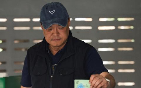 泰国看守首相、泰自豪党党魁阿努廷星期天（2月8日）在武里南府的一个投票站投下手中的选票。（路透社）