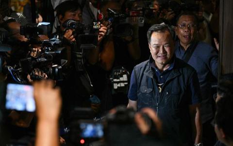 泰国看守首相、泰自豪党领袖阿努廷星期天（2月8日）晚上抵达曼谷的党总部时，面带笑容回应媒体。（法新社）