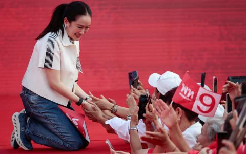 泰国前首相、达信女儿佩通坦2月6日在为泰党于大选前的最后一场造势活动为候选人站台拉票时，跪在台上与支持者握手。佩通坦因去年与柬埔寨前首相洪森的一通电话，被泰国宪法法院裁定违反道德准则而遭解职。（路透社）