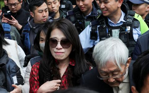 香港壹传媒创办人黎智英的妻子李韵琴（红衣者）与天主教香港教区荣休主教陈日君（右一）星期一（2月9日）到法院旁听判刑，步出法院时被媒体包围。（路透社）