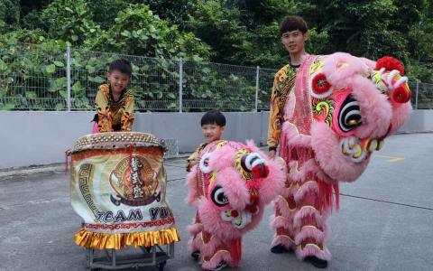林凯腾（中）和8岁的表哥石航峯（左），从小都跟着林明豪（右）到处演出，耳濡目染间培养了对采青的兴趣。（邝启聪摄）