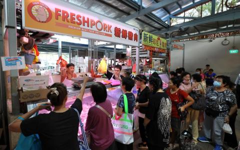 黄埔巴刹的猪肉摊，还没到早上9时便排起了长长人龙，顾客拎着购物袋、推着小推车，耐心在队里等候选购最满意的猪肉。（梁麒麟摄）