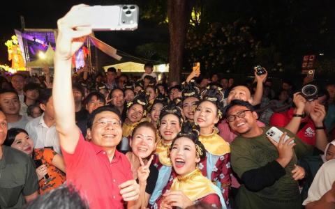 总理兼财政部长黄循财（红衣）为春到河畔活动主持开幕礼，还与现场观众及新加坡华族舞蹈剧场的舞者们自拍留念。（谢智扬摄）