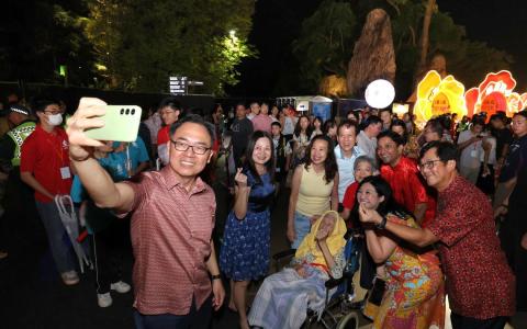 文化、社区及青年部兼人力部政务部长迪内希（后排右二）、榜鹅集选区议员杨涴淩（前排右一），以及武吉班让区议员连荣华（前排左一）大年初二（2月18日）晚上到访春到河畔，同现场公众合影。（ 梁麒麟摄）