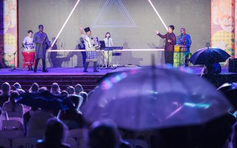 春到河畔星期二闭幕，节目主题为“和谐之夜”，台上是本地多元种族乐团yIN Harmony的动听演奏，台下是穿雨衣、撑伞，热情未减的观众。（李冠卫摄）