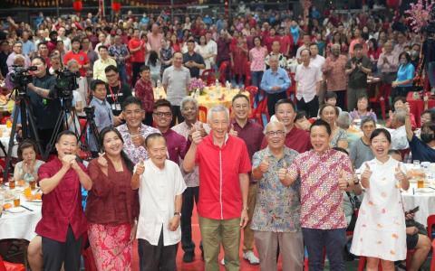 国务资政李显龙（左四）在德义区新春晚宴上，宣布宏茂桥基层组织第二顾问杨敦清（左三）和华素博士（右三）已在上个月底卸任。接下来将由负责静山区事务的宏茂桥集选区议员娜蒂雅（左二）协助李资政照顾德义居民。出席晚宴的还包括宏茂桥集选区议员赖添发（左一）、杰乐（第二排左一）和数码发展及新闻部兼教育部政务部长刘洁敏（右一），以及杨厝港区议员叶汉荣（右二）。（谢智扬摄）