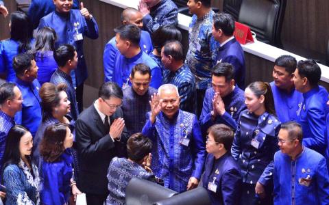 泰国自豪党议员索蓬（中间挥手者）星期天（3月15日）获得大多数国会议员支持，当选新一届国会下议院议长后，同僚纷纷向他道贺。（新华社）