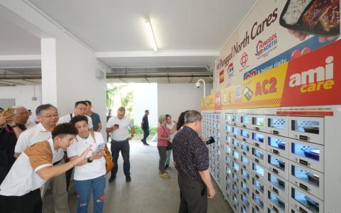 榜鹅集选区议员颜金勇（左二）出席餐食贩卖机推介活动，并与到场居民互动。（谢智扬摄）