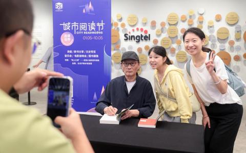 中国著名作家、艺术家金宇澄在“城市阅读节2026”主讲“城市——文学的摇篮和故乡”，活动吸引约500名读者。图为金宇澄（左一）在分享会后为读者签书。（李冠卫摄）