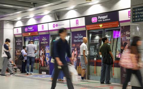 地铁东北线榜鹅站（Punggol MRT Station）的月台于2025年12月26日约早上8点53分人来人往，乘客排队等候地铁列车。这个地铁站自今年起纳入灵活行程规划，奖励乘客避开早上尖峰时段乘车，以更好地分散人流。（SPH Media Limited）