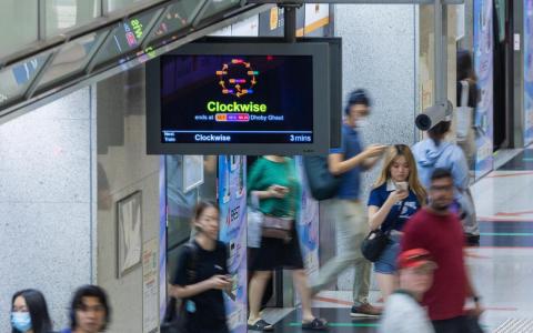 CMG20260529-NgohSB01/吴先邦/黄佳琪/To view enhanced wayfinding signs on the Circle Line[Promenade station [meeting point at Exit C- Passenger Service Centre]] Commuters wait near a train arrival screen showing the new clockwise Circle Line service information at Promenade station on 29 May 2026. The enhanced wayfinding system uses clearer direction labels and colour-coded station indicators to guide commuters. 中文： 2026年5月29日，通勤者在宝门廊地铁站月台候车，附近的列车到站显示屏显示新的顺时针环线服务信息。新导向系统采用更清楚的方向标示和以颜色区分的车站标识，协助乘客辨认路线。（SPH Media Limited）
