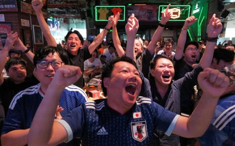中国球迷6月21日齐聚上海一家酒吧观看日本对垒突尼斯的世界杯小组赛。图为中国球迷在为日本“蓝武士”的胜利欢呼庆祝。（路透社）