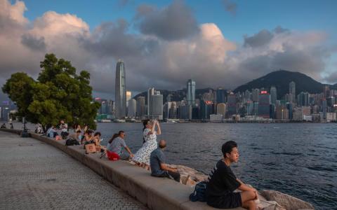 香港保安局星期一（6月29日）向立法会议员提交文件，建议修订沿用数十年的性罪行法例。图为人们6月23日坐在香港维多利亚港旁的滨海长廊上。（法新社）