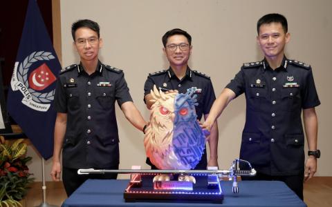 警察总监侯光辉（中）、副警察总监（调查及情报）兼刑事侦查局局长张伟汉（左），以及网络指挥处司令王兴顺高级助理警察总监（右）一同触摸象征新指挥处的猫头鹰徽章，开启新篇章。（郑一鸣摄）