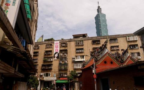 台北101大楼耸立在住宅楼与寺庙屋顶后方的背景中。图摄于今年5月12日。（路透社档案照片）