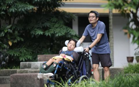 潘伟盛几年前放下工作，全职在家照顾儿子潘文杰，他每天都会陪儿子到组屋楼下感受大自然。他希望，社区设施和活动的规划能考虑特需孩子的需求，让他们也有机会与其他人互动。（郑一鸣摄）