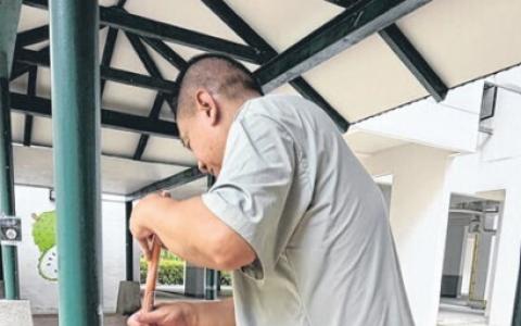 梁先生每早用洗衣粉刷洗柱子与地面。（新明日报）