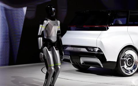 4月24日，北京国际汽车展览会上，一台人形机器人站在吉利汽车发布的Robotaxi原型车“Eva Cab”旁。（路透社）
