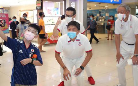 国务资政兼国家安全统筹部长张志贤（右）昨天与出征盛港集选区的总理公署部长黄志明（前排中）和黎鸿业一同走访鲤河大厦时，应一名男孩的要求自拍合照。（陈来福摄）