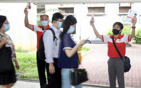 2020年大选竞选期间，丰加北单选区新加坡前进党候选人袁麒钧（右一）走访选区，分发竞选传单。（档案照）