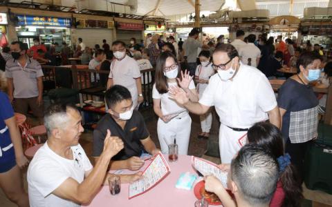 刚在本届大选中带领团队成功守住西海岸集选区的通讯及新闻部长易华仁（右二）早前与新人王心妍在竞选期间走访文礼熟食中心与巴刹。（档案照片）
