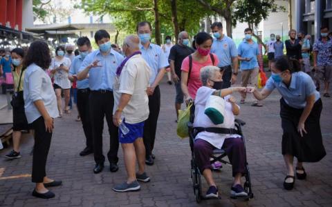 工人党盛港集选区候任议员辣玉莎（左一）、林志蔚（左二）、蔡庆威（左四）以及何廷儒（右一），昨早到鲤河大厦答谢盛港选民时与民众互动。盛港是工人党在本届大选攻下的第二个集选区，这让该党的国会议席从六个增至10个。（海峡时报）