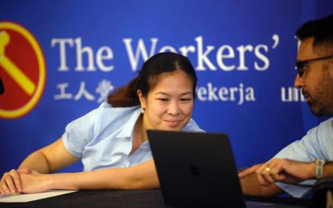 工人党秘书长毕丹星（右）和领军盛港集选区团队的何廷儒在记者会上浏览媒体代表的视讯提问。（海峡时报）