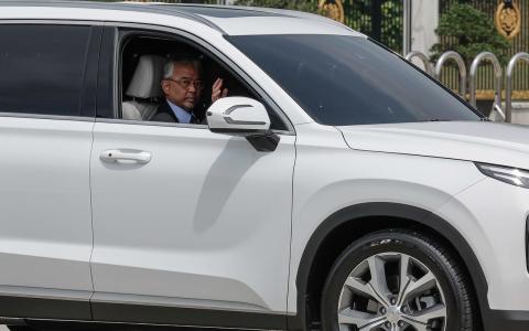 马来西亚国家元首苏丹阿都拉中午时分驾车外出，与现场守候的媒体挥手打招呼。（马新社）