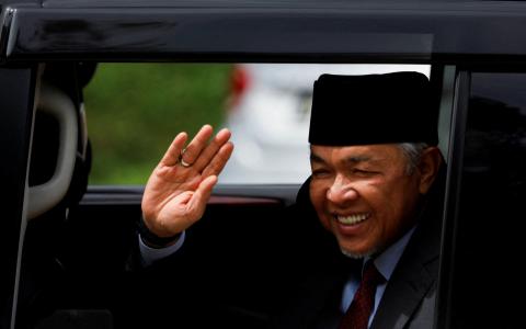 阿末扎希强调，他不会因国阵及巫统在第15届全国大选取得历来最差成绩而辞职，他说：“我不辞职。”图为阿末扎希23日离开国家王宫时，向摄影师挥手。（路透社）