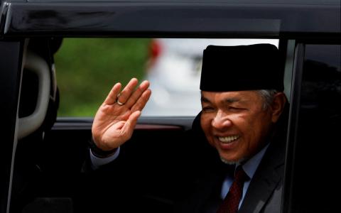 国阵及巫统主席阿末扎希出席首相安华的宣誓仪式，一般相信巫统和希盟会共组政府。照片于11月23日阿末扎希离开国家王宫时所摄。（路透社）