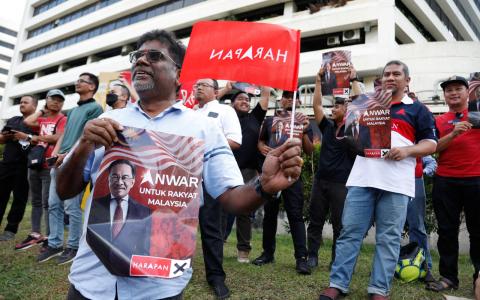 马来西亚新首相安华强调，他领导的政府会不分种族，维护人民的福利。图为安华的支持者11月24日下午聚集在国家王宫外，庆祝安华受委首相。（路透社）