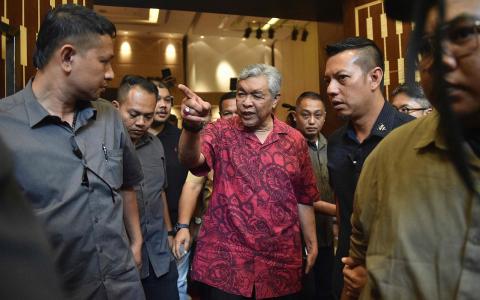 巫统及国阵主席阿末扎希（左三）首次领军大选但却取得历来最差的冲击，这在巫统及国阵内部引发不满并要求阿末扎希辞职。不过，巫统最高理事会星期四的会议议决继续支持阿末扎希担任巫统及国阵主席。（法新社）