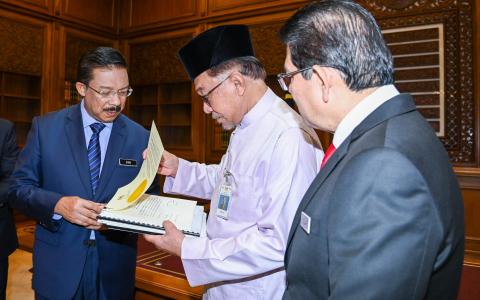 马来西亚新首相安华（中），25日第一天到布城首相署上班。（法新社）