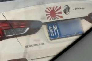 视频显示，山东滨州一辆贴着日本旭日军旗的轿车在街上行驶。（视频截取）