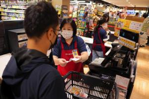 台湾台北全联福利中心超市一名工作人员7月10日为顾客服务。（路透社）