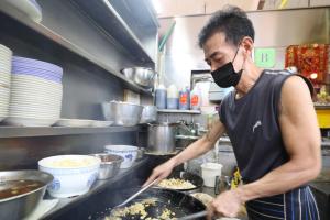 张再发化疗期间仍每天到摊位掌勺。（庄耿闻摄）