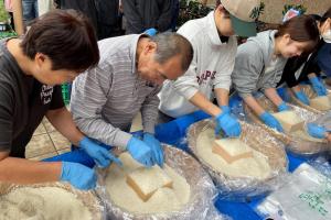 日本东京一个农贸市场近期大搞促销活动，让顾客用小木盒装尽可能多的米来买平价米。（路透社）