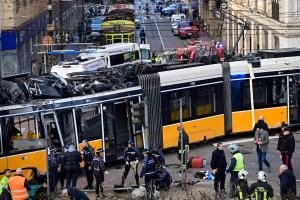 米兰闹市一列电车脱轨，撞进一家商店橱窗，导致两人死亡和近40人受伤。警察与消防员在现场展开救援。（法新社）