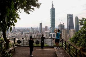 台湾官方上调今年经济增长率至逾9%，创16年新高。图为台北市民以台北101大楼为背景留影。（路透社）