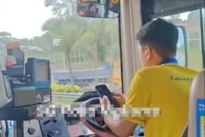 车长将双臂抵在方向盘上，并用双手在手机上打字，行径危险。（取自SG Road Vigilante脸书）