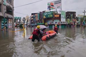 米克拉过境台湾时引发暴雨，导致台湾部分地区停摆，约600万人停工停学。台湾中央社6月26日发布的照片显示，连夜暴雨在台南引发严重洪涝，消防员出动救援艇将受困者转移至安全地点。（法新社）