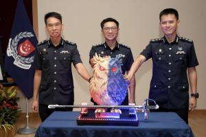 警察总监侯光辉（中）、副警察总监（调查及情报）兼刑事侦查局局长张伟汉（左），以及网络指挥处司令王兴顺高级助理警察总监（右）一同触摸象征新指挥处的猫头鹰徽章，开启新篇章。（郑一鸣摄）