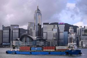 香港6月PMI升至52，增速为四个月最佳。图为载着集装箱的货轮航经香港维多利亚港，摄于7月1日。（法新社）
