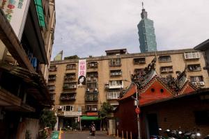 台北101大楼耸立在住宅楼与寺庙屋顶后方的背景中。图摄于今年5月12日。（路透社档案照片）