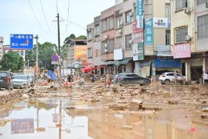 受台风“美莎克”带来的强降雨及上游来水叠加影响，广西贵港多地遭遇洪涝灾害。图为7月9日在贵港市覃塘区三里镇合新街，洪水退去后，居民进行清淤。（中新社）