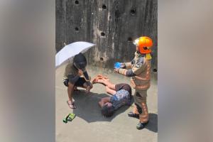 一名男子下沟撑伞为妇女遮阳。（受访者提供）