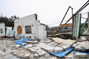 今年以来袭击中国的最强台风“红霞”，星期天（7月26日）凌晨在广东惠州市登陆。图为惠州市惠东县平海镇一处养殖场的墙壁被台风吹倒。（新华社）